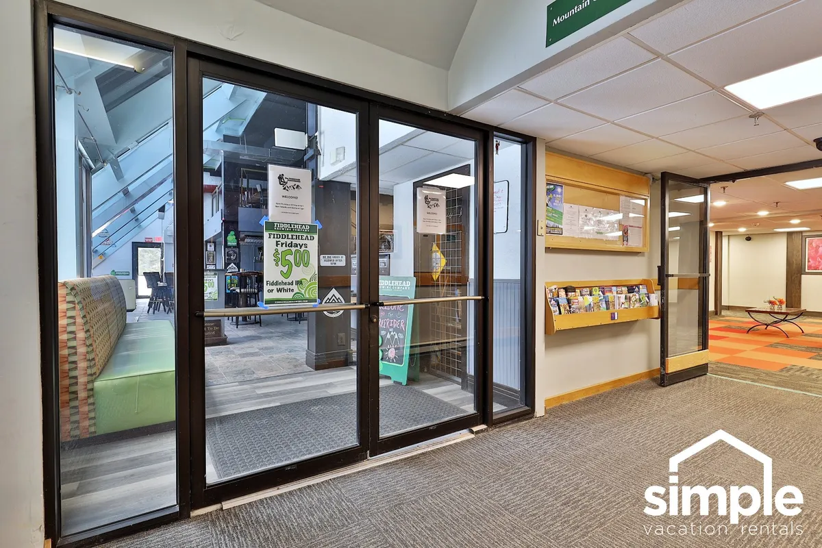 This image captures the reception area, featuring glass doors that let in natural light and a rack with brochures and local information. The space is friendly and suggests a place where guests can gather information about local attractions, hiking trails, and area activities as soon as they arrive.